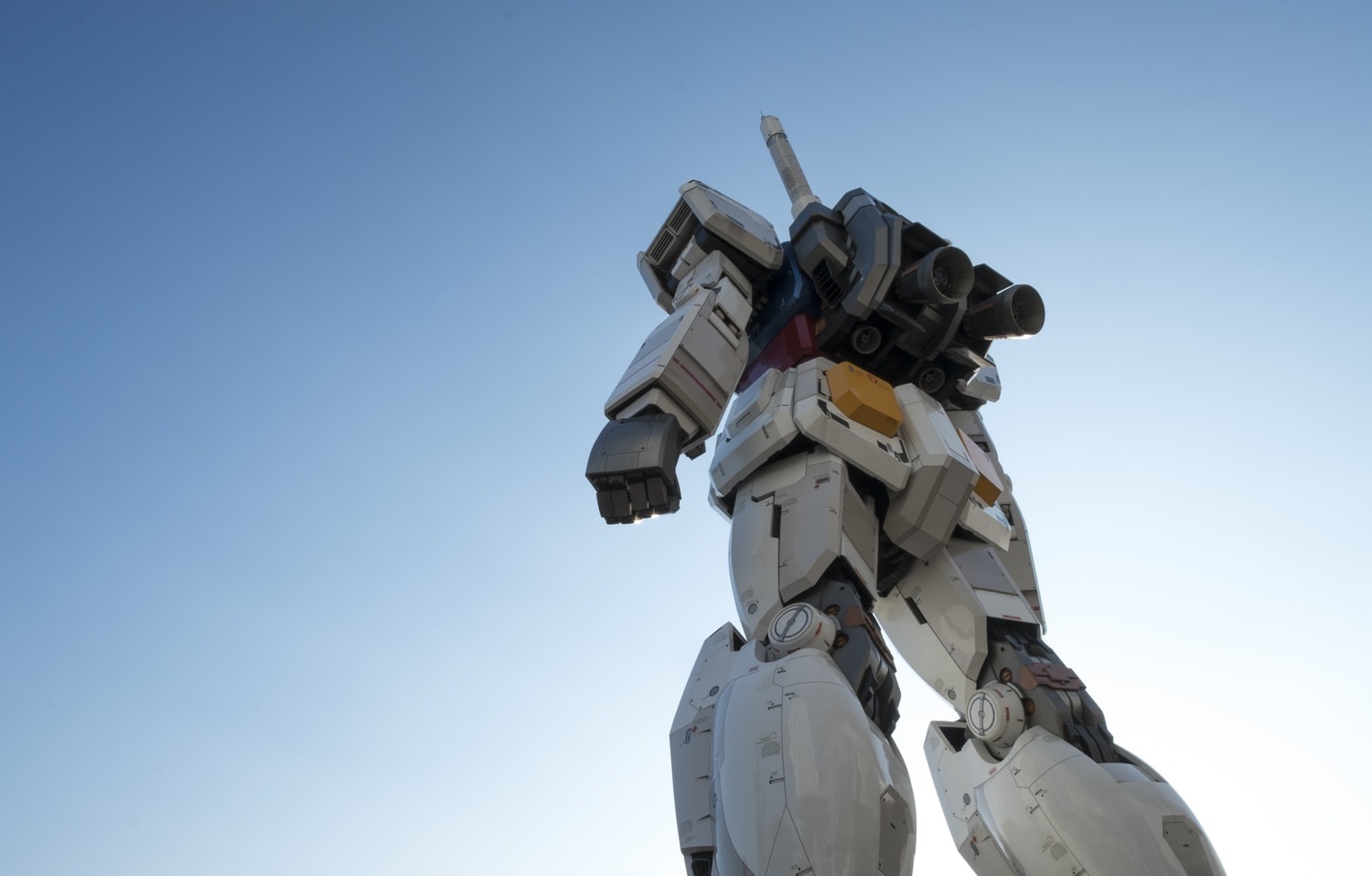 Low angle shot of a robot against a blue sky.