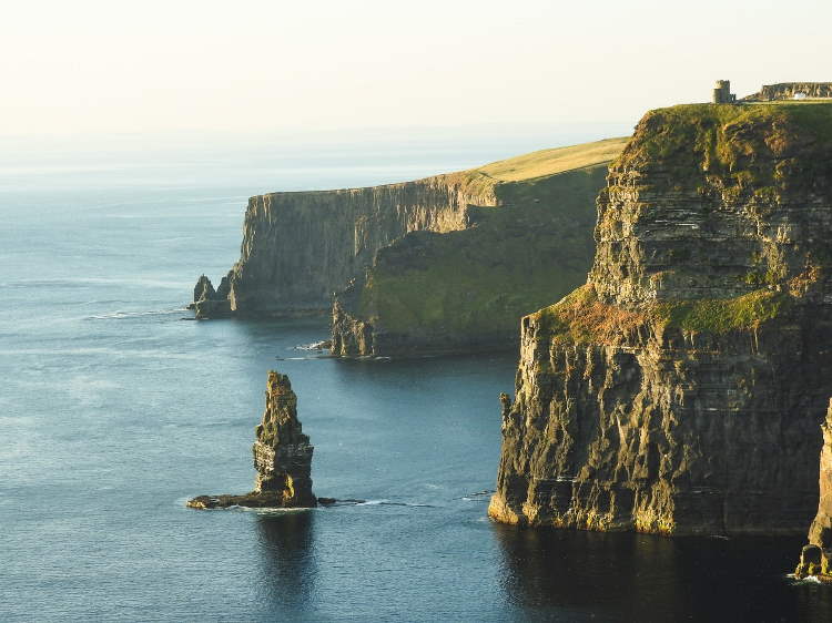Irish coastline, with very vlue ocean and green cliffs and rocks.