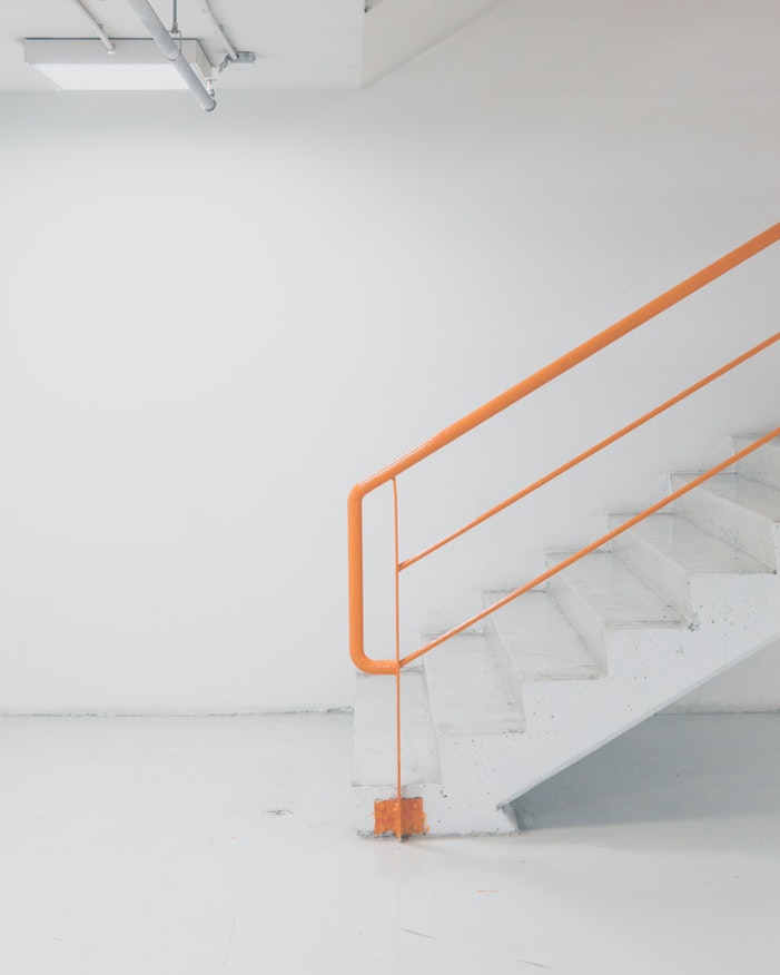 White stairs with an orange railing