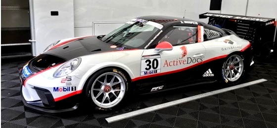 Racing car in red, white, and black, and ActiveDocs branding stickers on it.