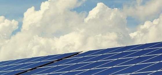 Solar panels and a blue sky with some fluffy clouds