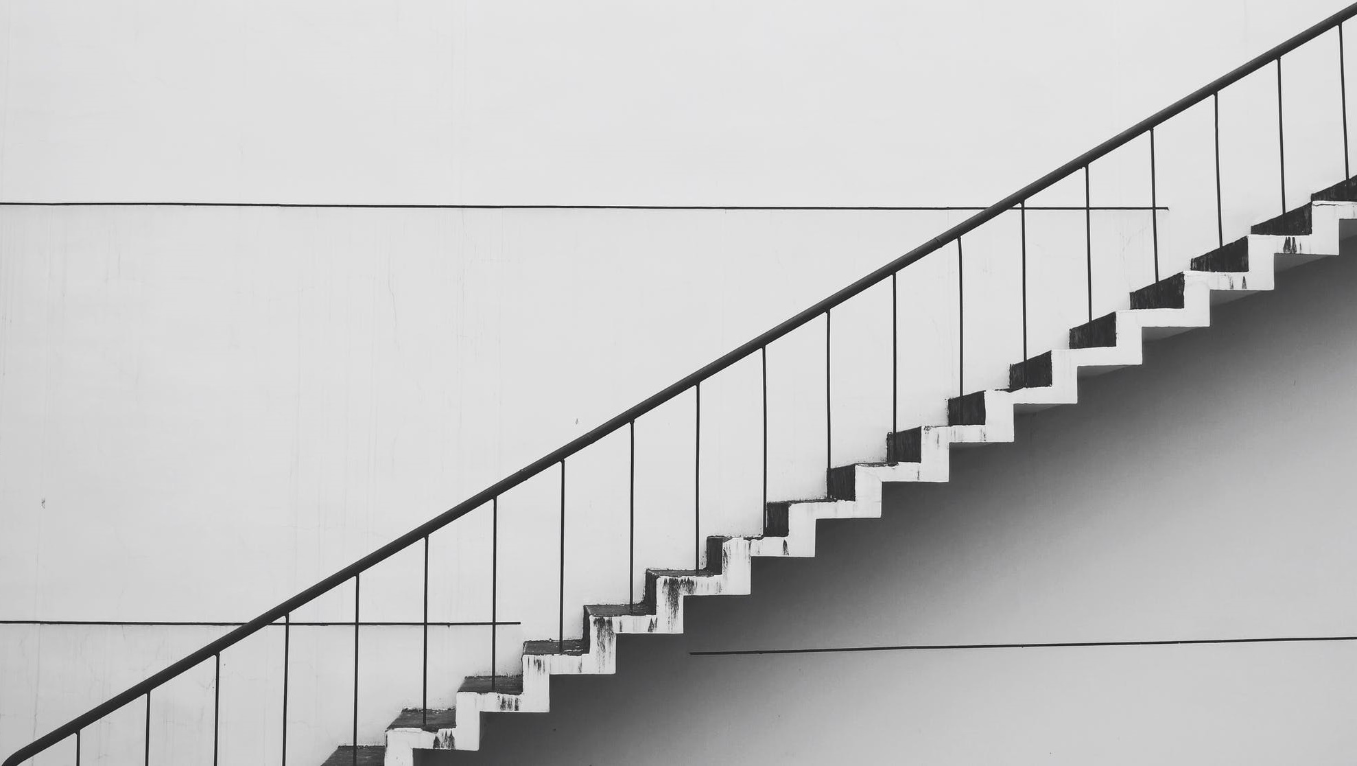 Photo of ascending stairs on a light gray background.