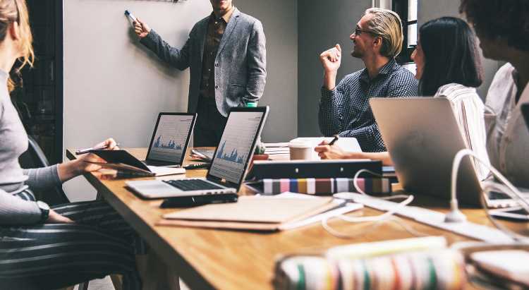 Person presenting to a boardroom full of people