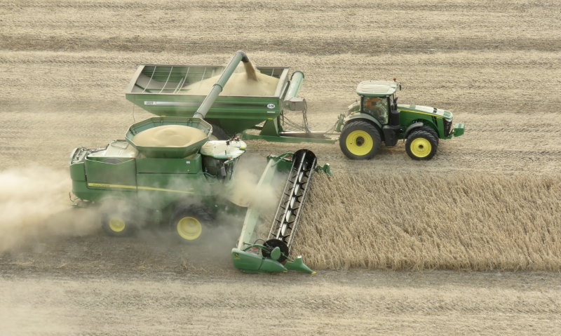 Tractor and harvester on a field.