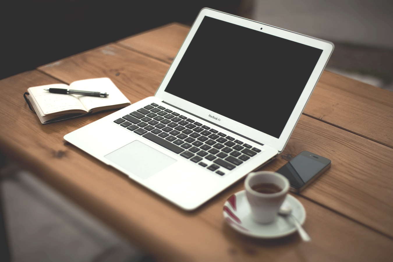 Neat workstation with laptop, notepad, and coffee.