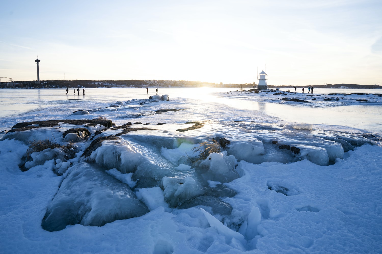 Winter, snowy view of water and the Tampere cityscape.