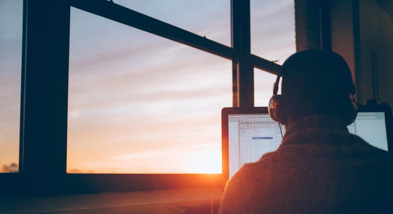 Man with a laptop at sunset