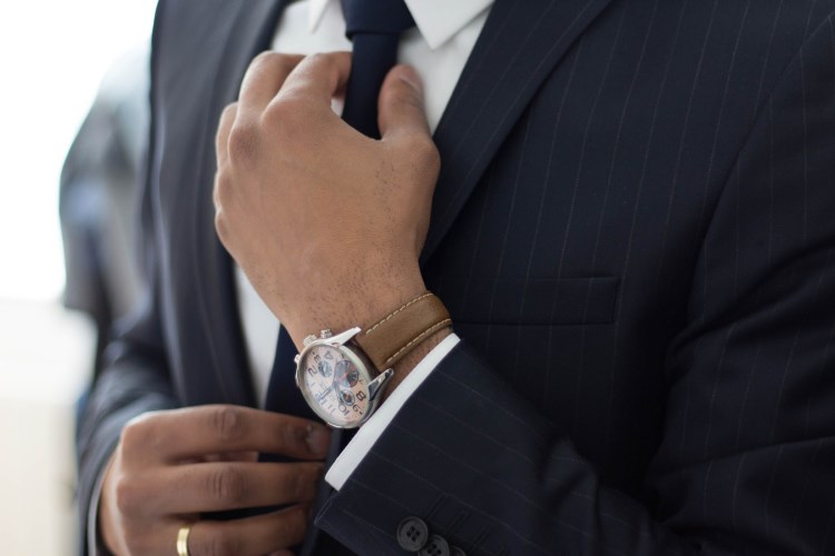 Neatly dressed man adjusting his tie