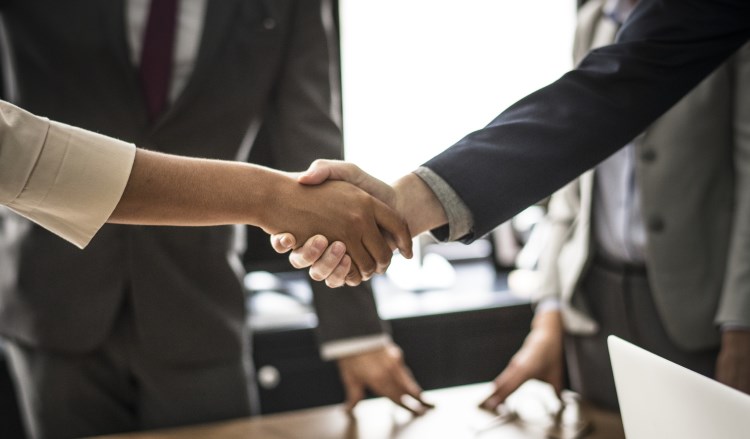 Pepole in neat suits shaking hands