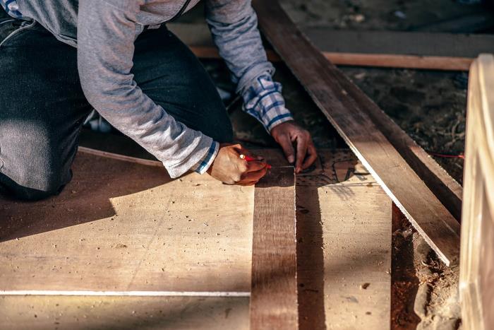 Person marking wooden planks