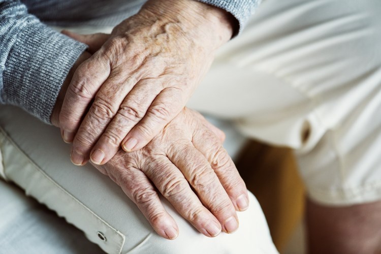 Wrinkled hands on someone's lap