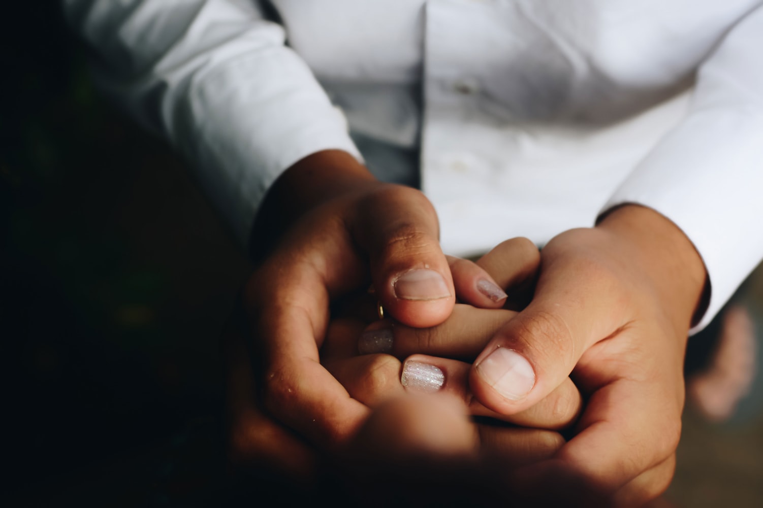 Closeup photo of someone's hands holding another person's hands.