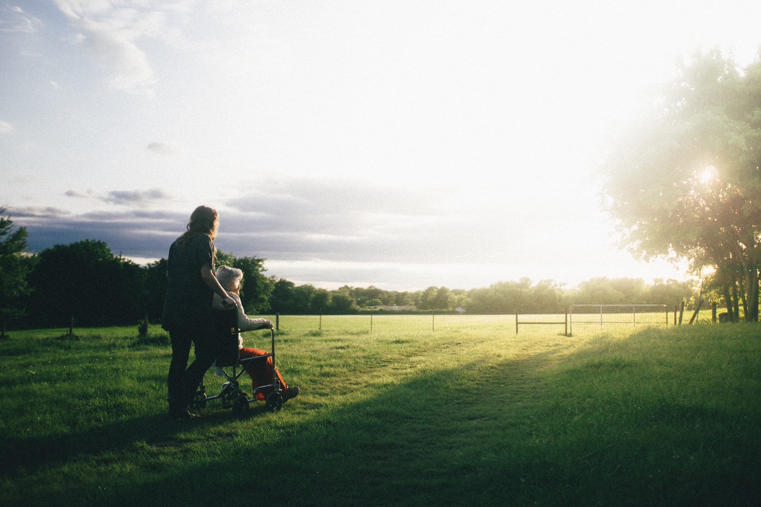 Blue and green, sunny landscape, with two people enjoying the outdoors.